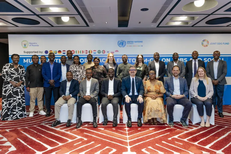 A group photo with some people standing and others seated in front of them.