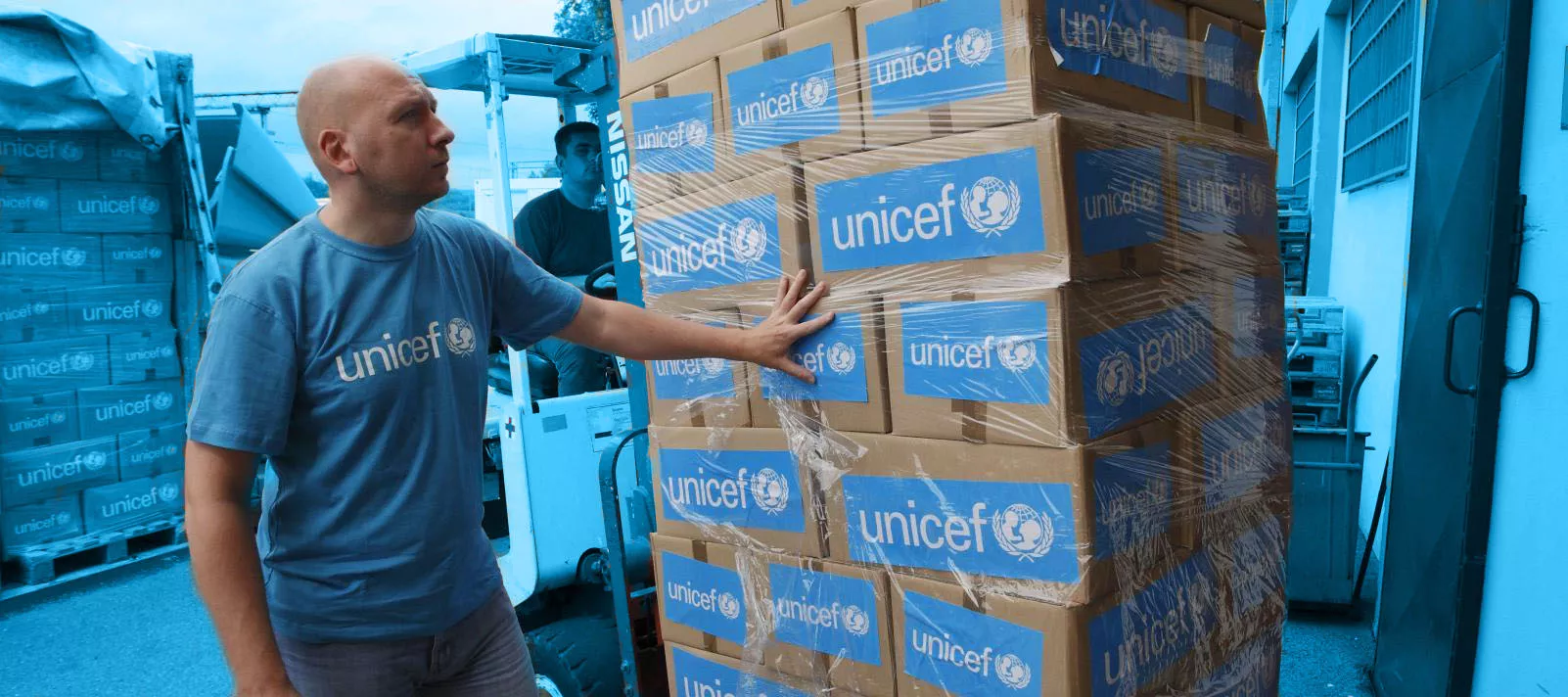 UNICEF worker with stacked goods during the emergency