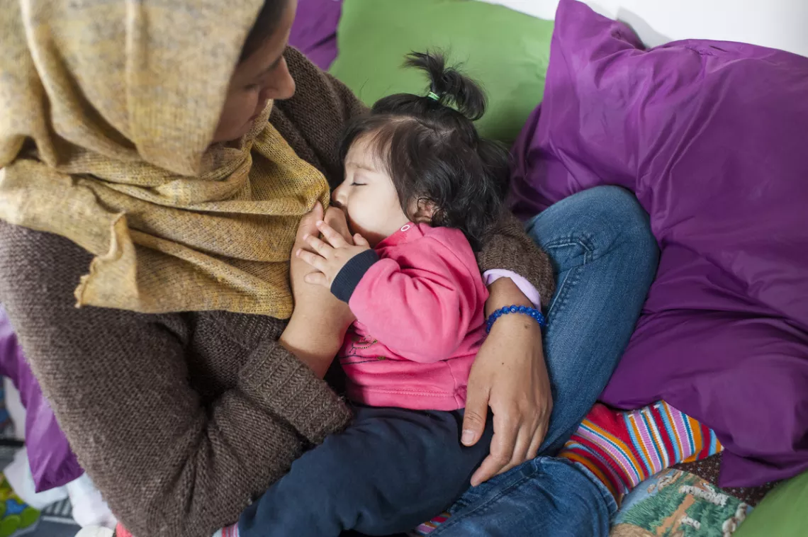 Mother breastfeeding her baby at a mother and baby corner