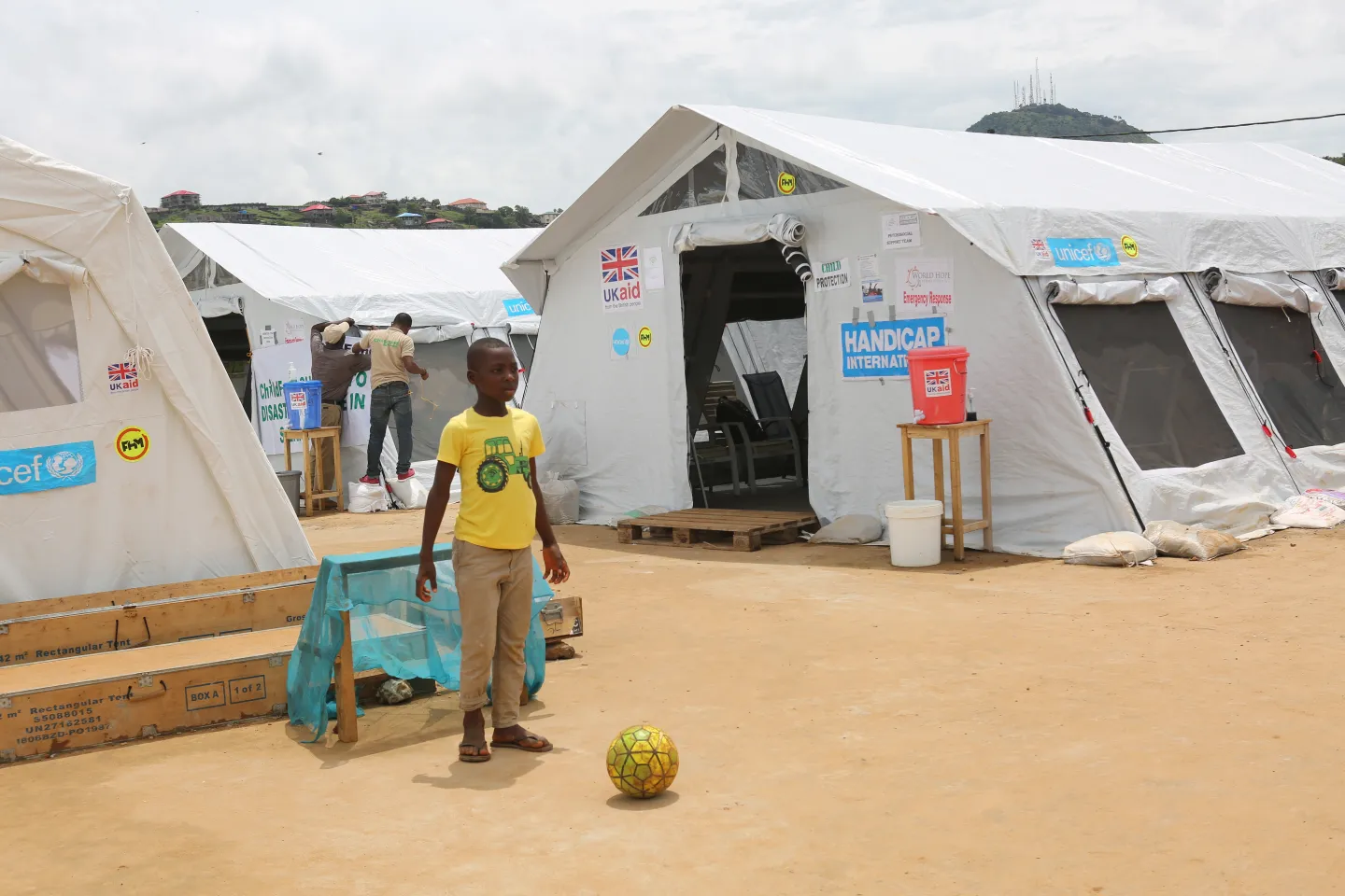A boy plays football at a temporary camp set up by the Government of Sierra Leone with support from UNICEF and other partners after flash floods and mudslide hit parts of Freetown in 2017.