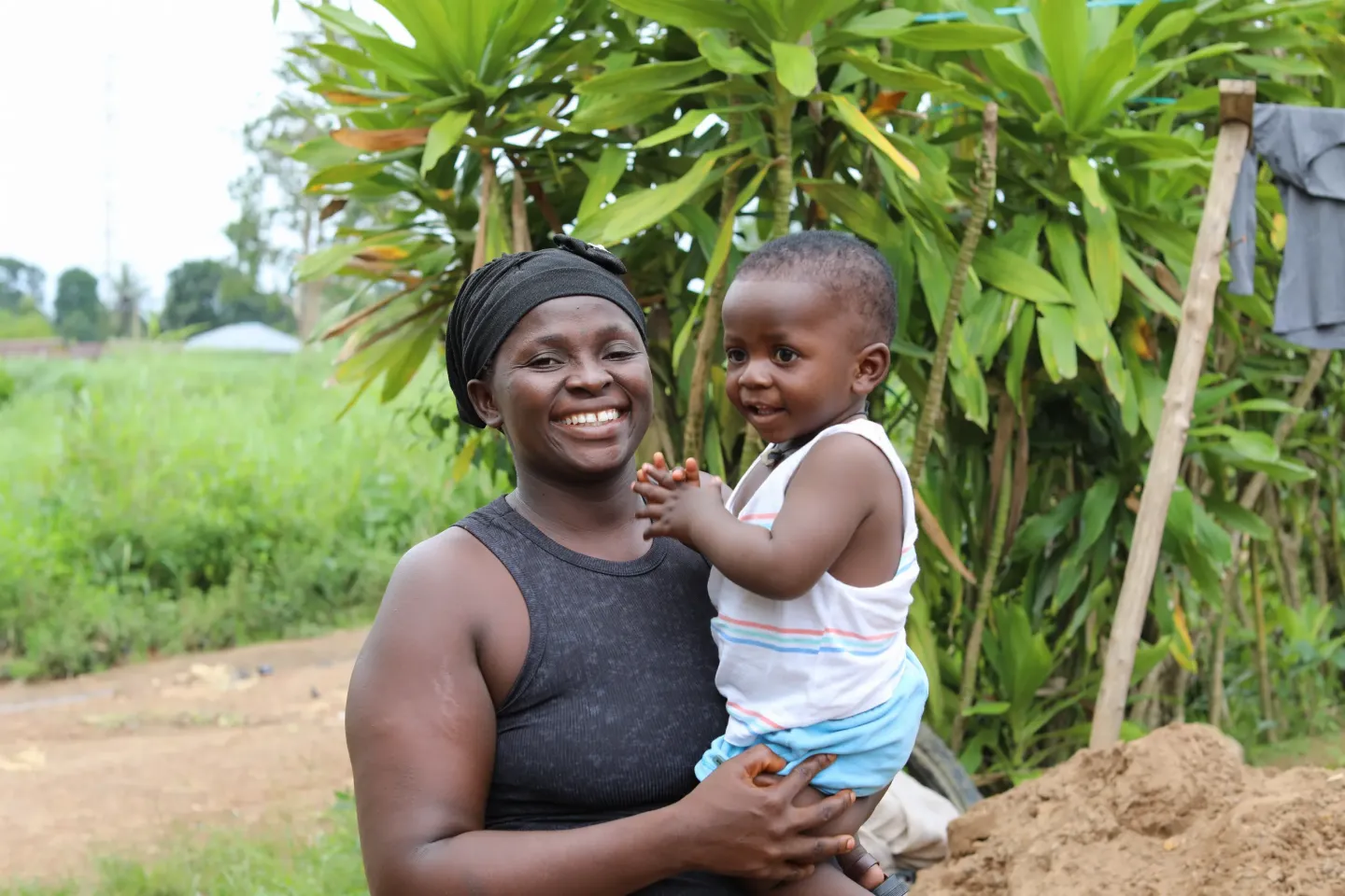 Musu Kamara stands with her son Harrison by their home in Pujehun. 