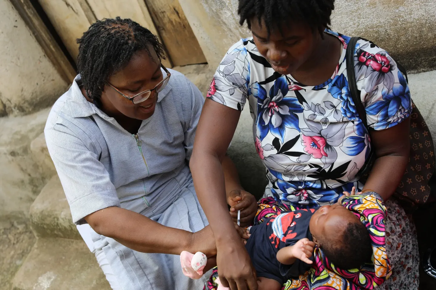 Health worker, Jenevia Johnson, vaccinates a six-week-old baby against childhood diseases during an outreach exercise in Waterloo community in Rural Freetown