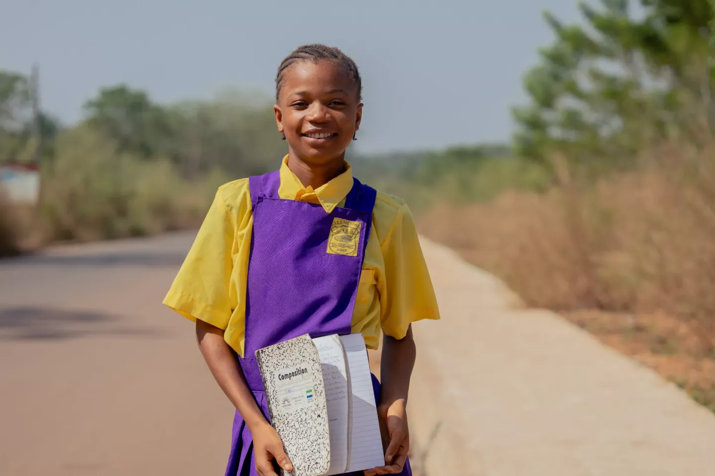 A schoolgirl stands by a roadside in Sierra Leone