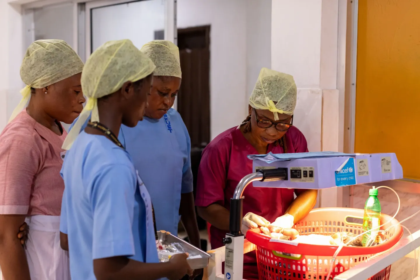 A group of health workers care for a sick baby inside a health facility in Sierra Leone.