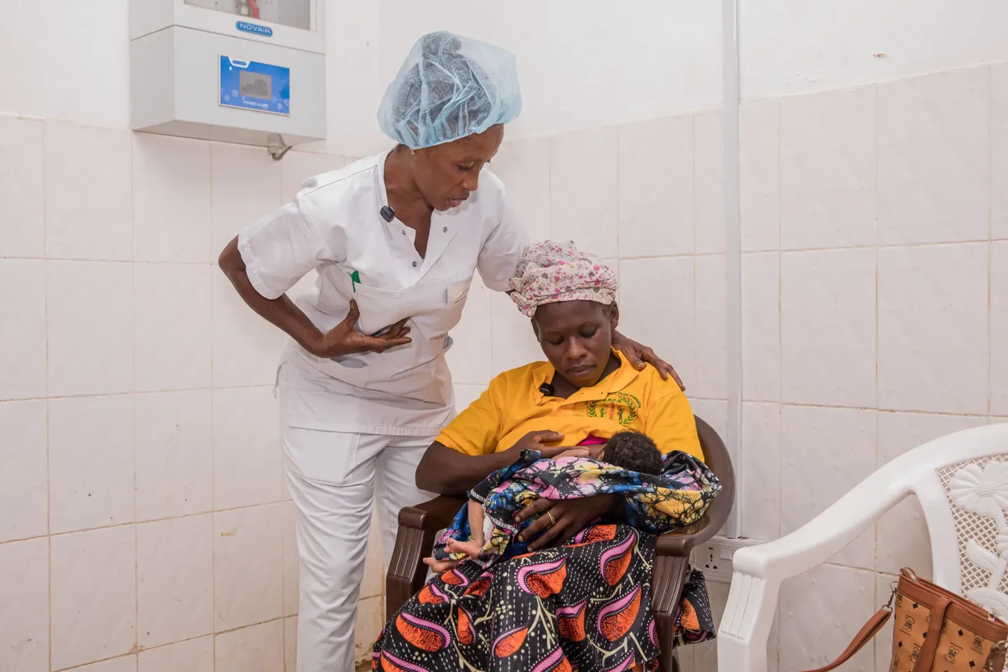 Nurse Saudatu Sesay supports Fatmata Conteh with breastfeeding at Makeni Regional Hospital.