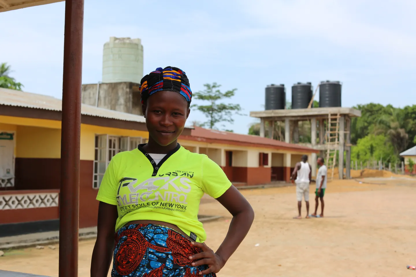 A pregnant woman stands outside a health facility in Sierra Leone