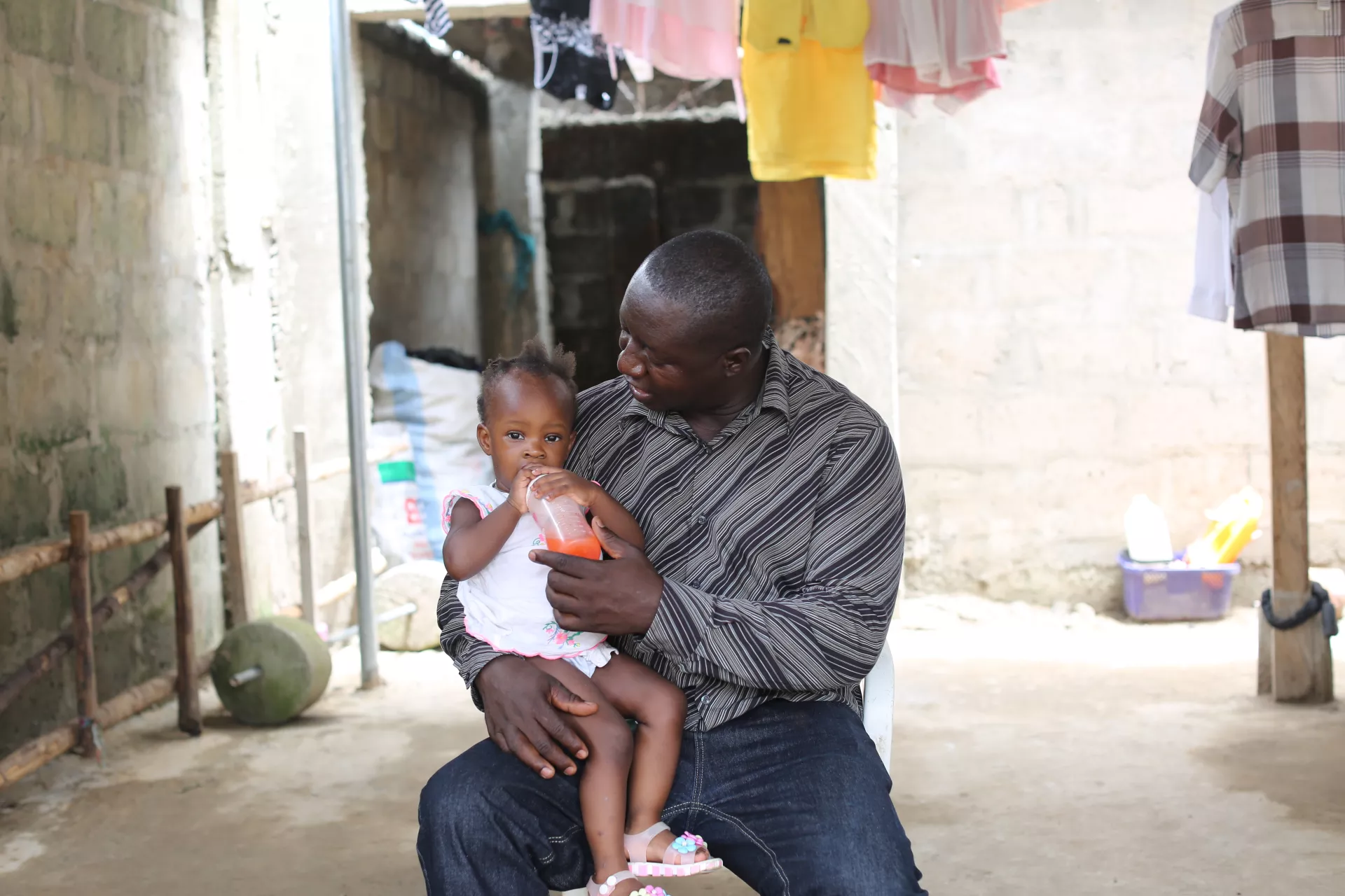 Yayah Bangura (a UNICEF staff) feeds his 19-month-old daughter Hafsa at their home in Freetown, before heading to work.