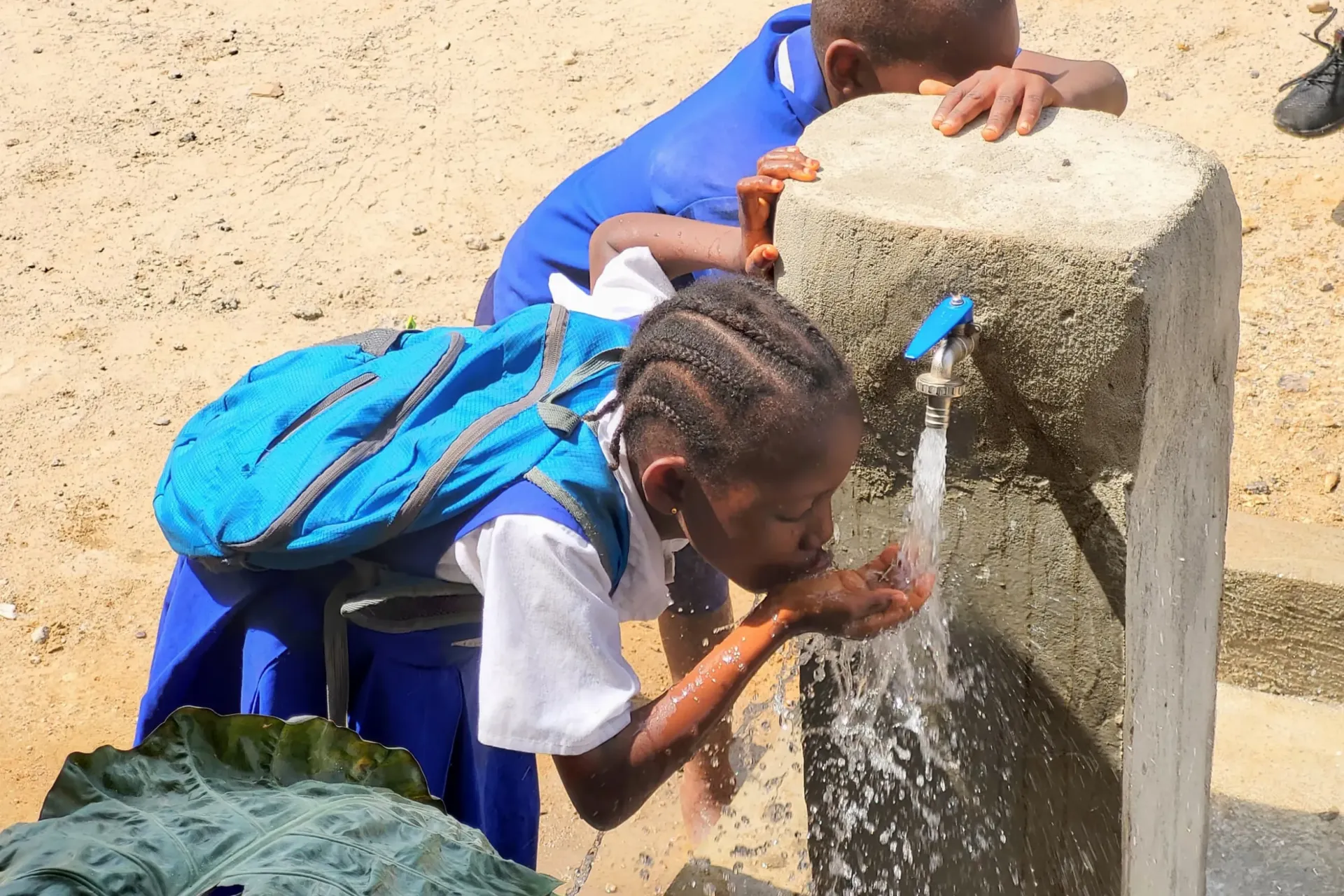 A schoolgirl drinks water from a tap in her school in rural Sierra Leone.