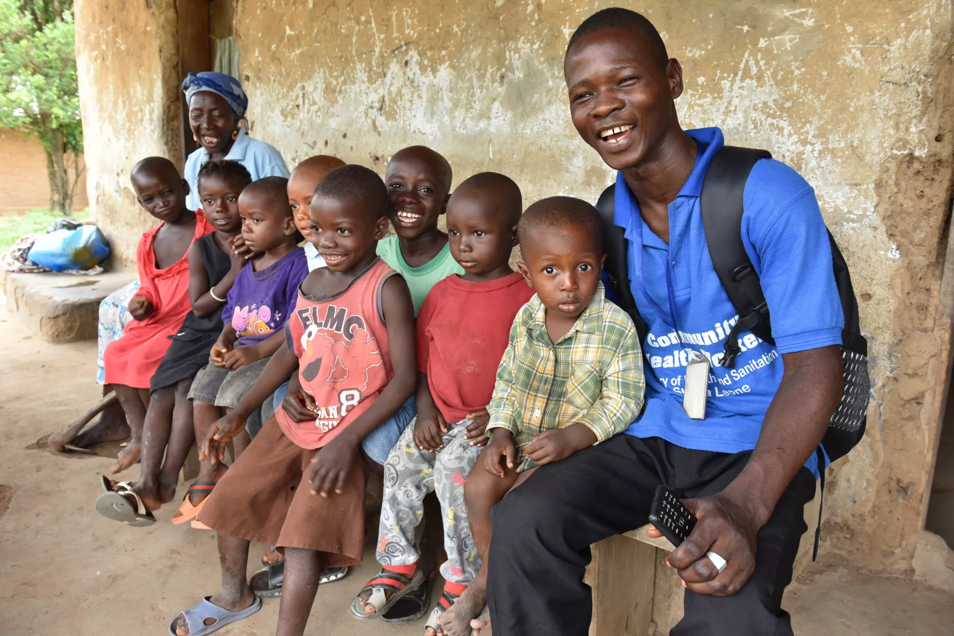 Community Health Worker Musa B. Jawara poses with just a few of the children who have benefited from routine immunization campaigns