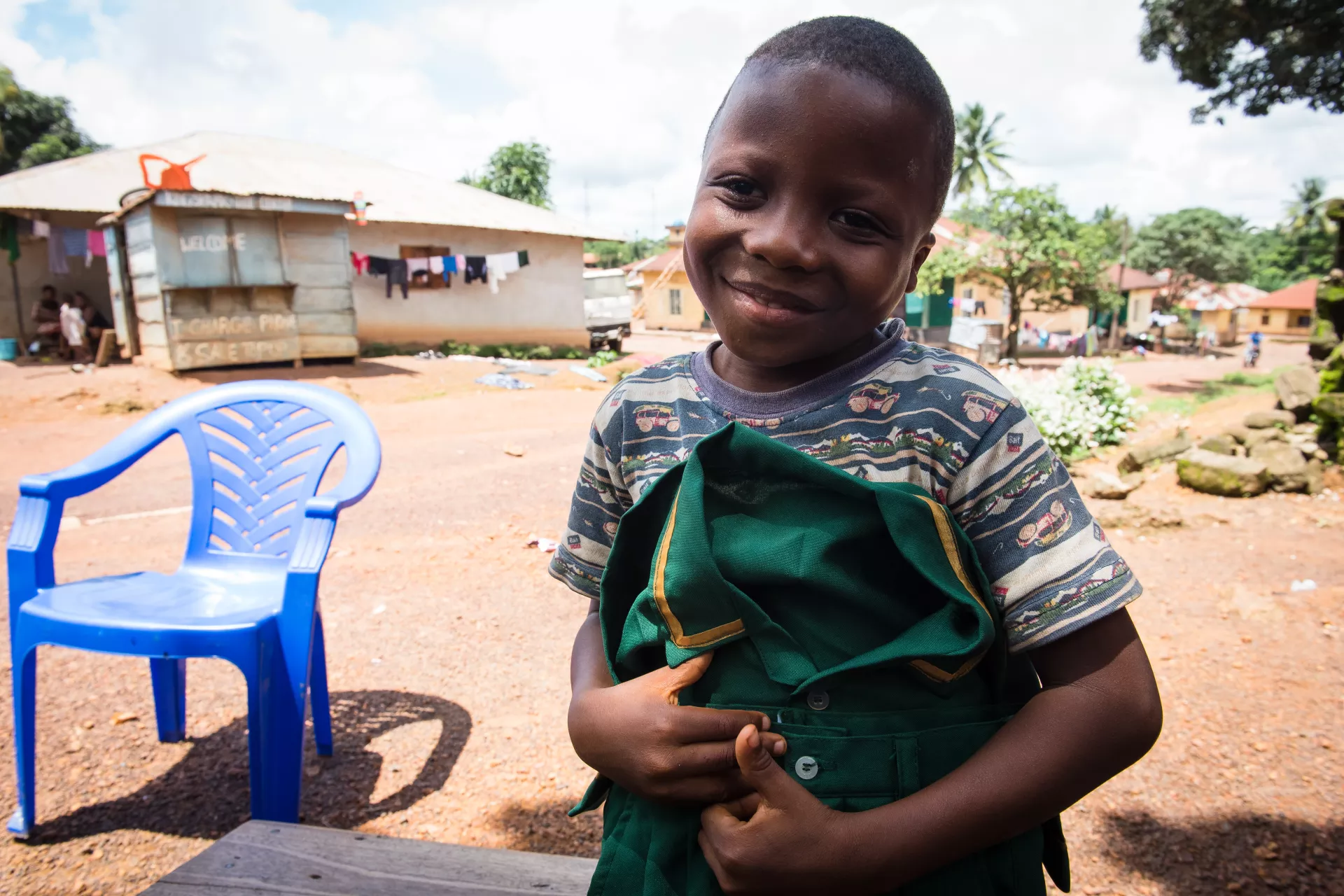 Six-year-old Lahai Charles shows off his pair of uniform outside his home in Kenema, eastern Sierra Leone