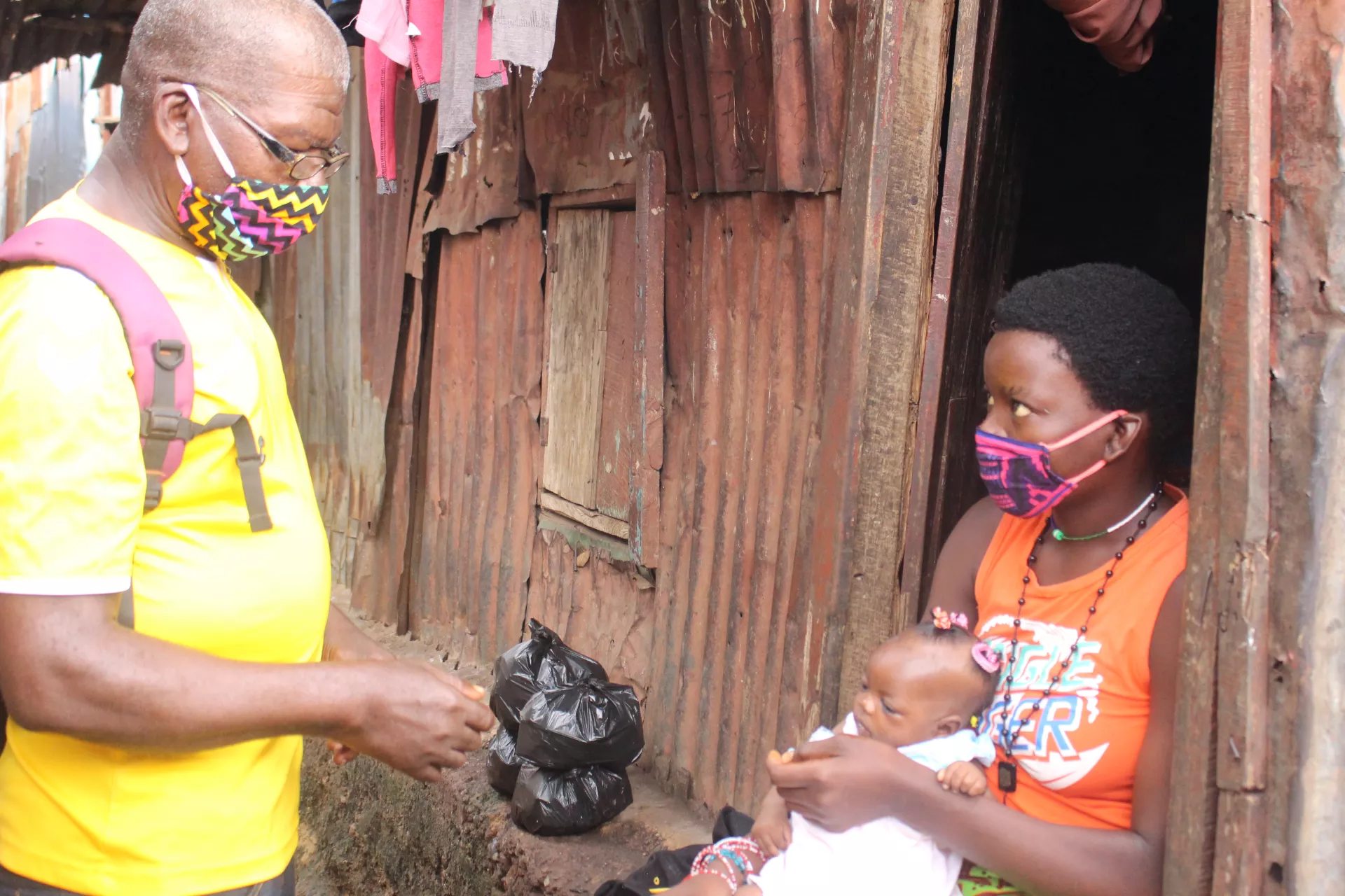 A Community Health Worker talks with a woman carrying a baby, in Freetown western Sierra Leone