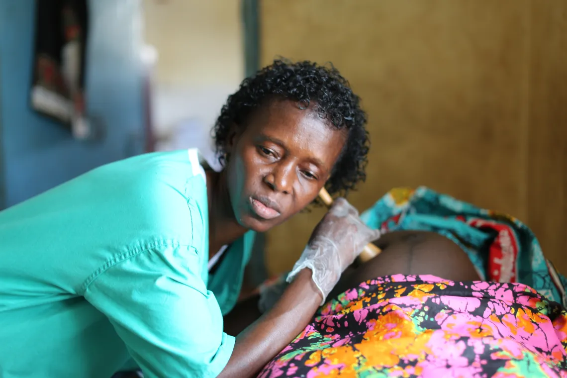 A nurse examines a pregnant woman at a health centre in Sierra Leone