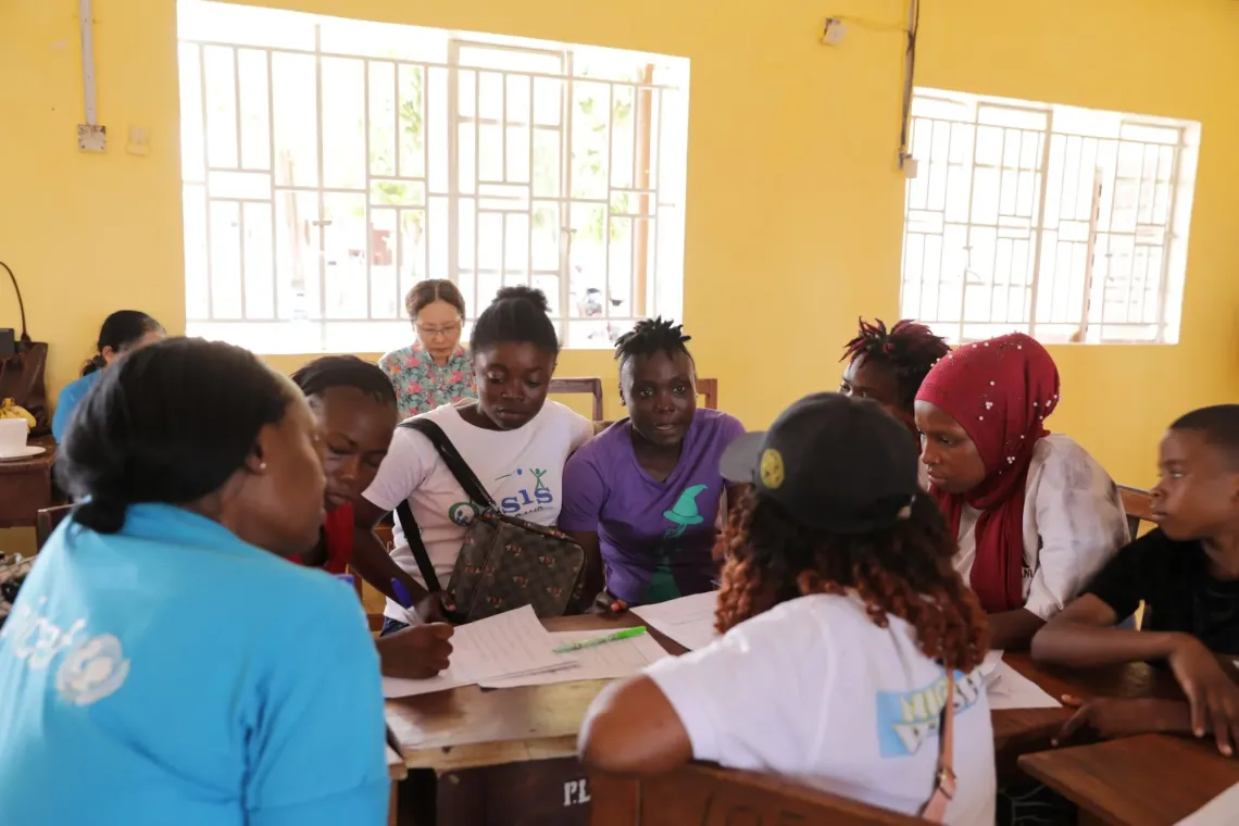 A UNICEF Sierra Leone programme staff engages a group of adolescents during a training session on Adolescent Health, Nutrition and Wellbeing in Port Loko