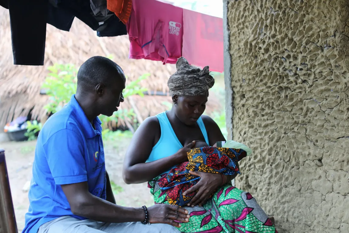 Community Health Worker Yusuf Musa provides breastfeeding guidance to a new mom Hawa during a follow-up home visit. 