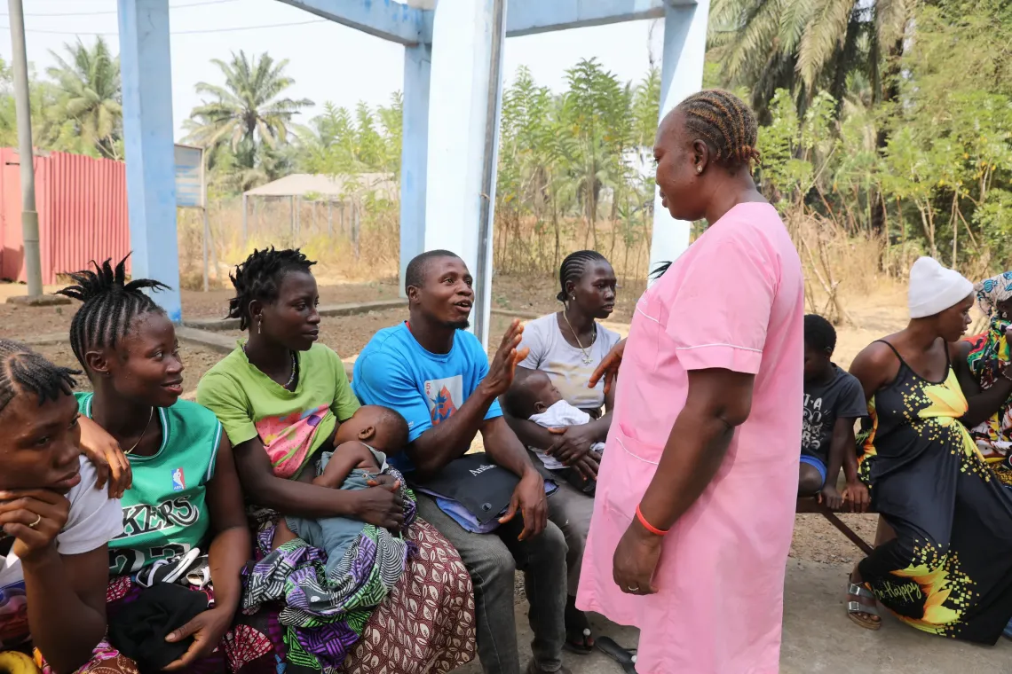 Mohamed Tholley, father of eight-month-old Morlai, asks a question during an engagement session at the Rokonta Community Health Center. 