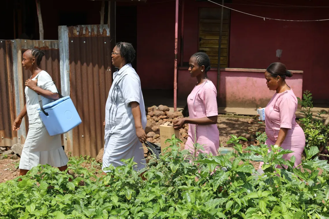 Jenevia (second) and her vaccination team entered Benguema community for an outreach exercise on tracing and vaccinating under-five children who are defaulting 