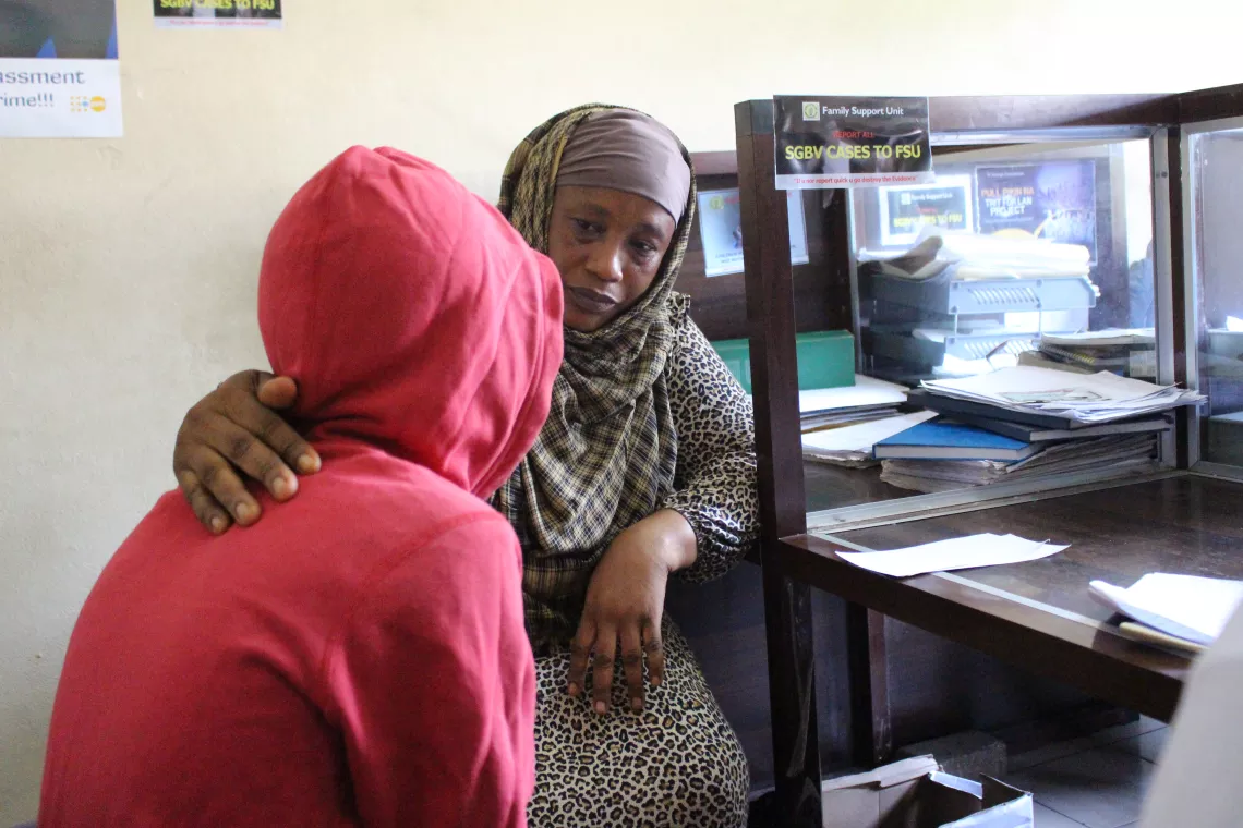 A woman talks to a child inside an office in Freetown.