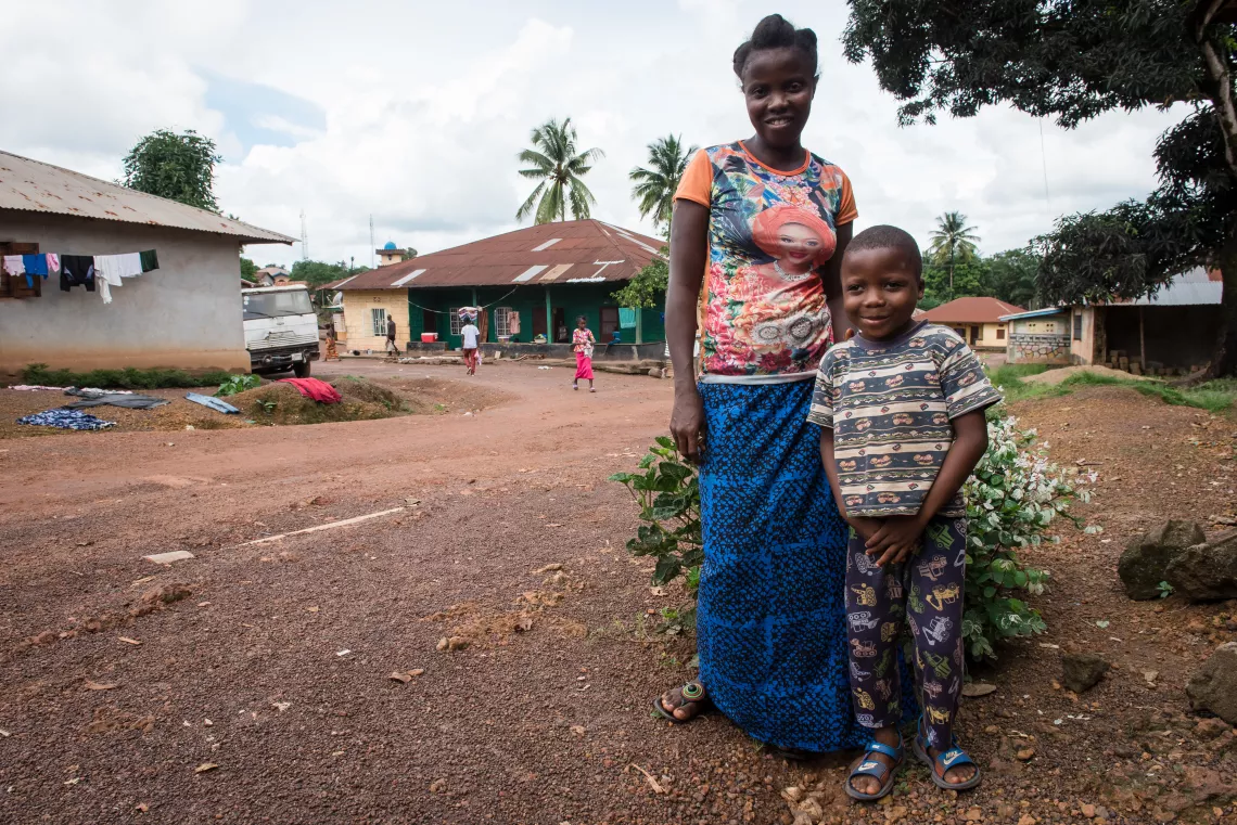 Six-year-old Lahai Charles stands with his mother Hawa, outside their home in Kenema, eastern Sierra Leone