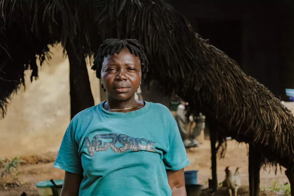 A woman stands outside her family home in Boama, Sierra Leone.
