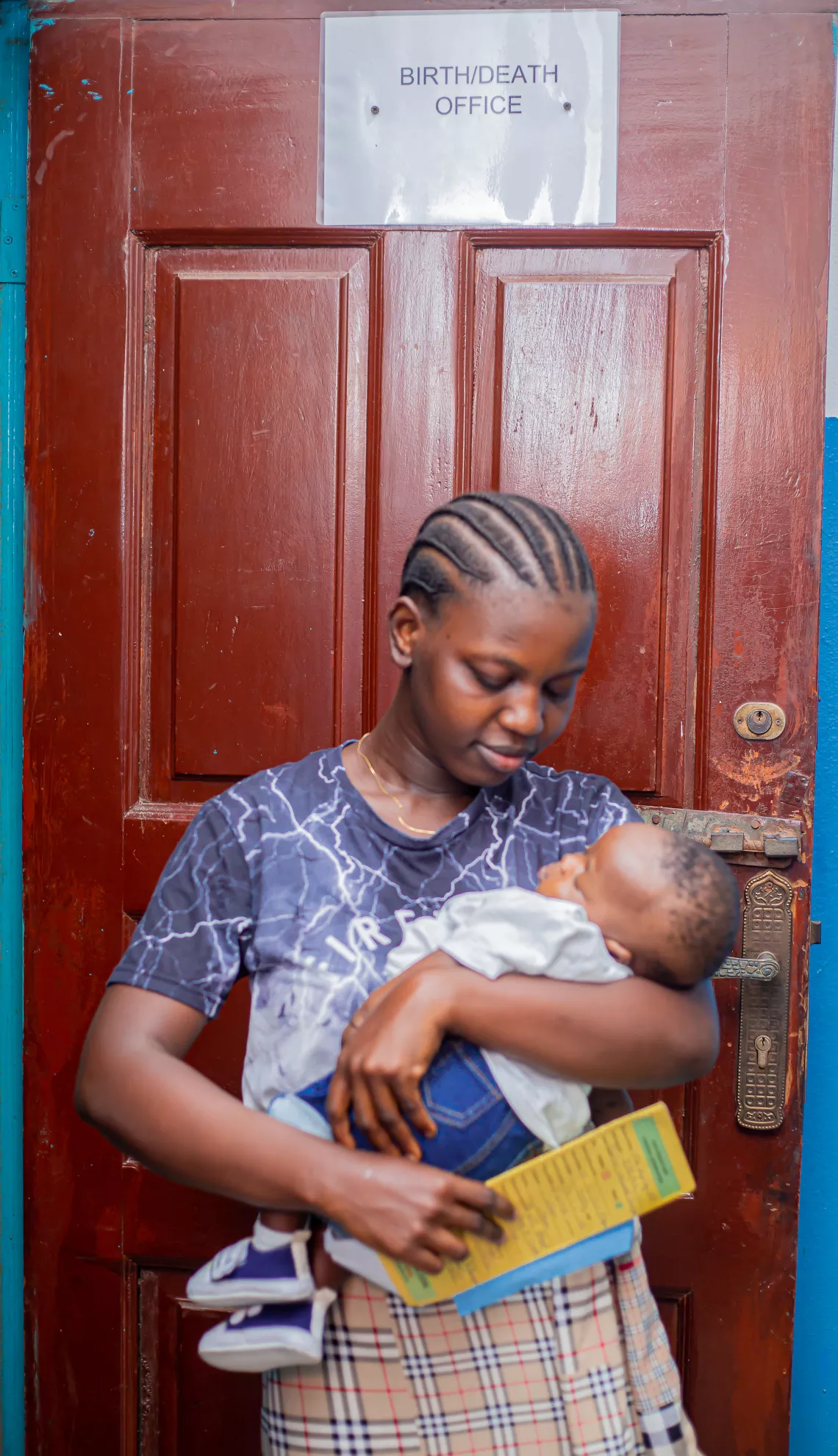 A mother carries her baby in her arms.