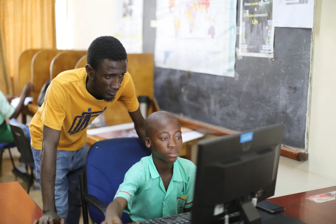 A young boy learns how to use a computer