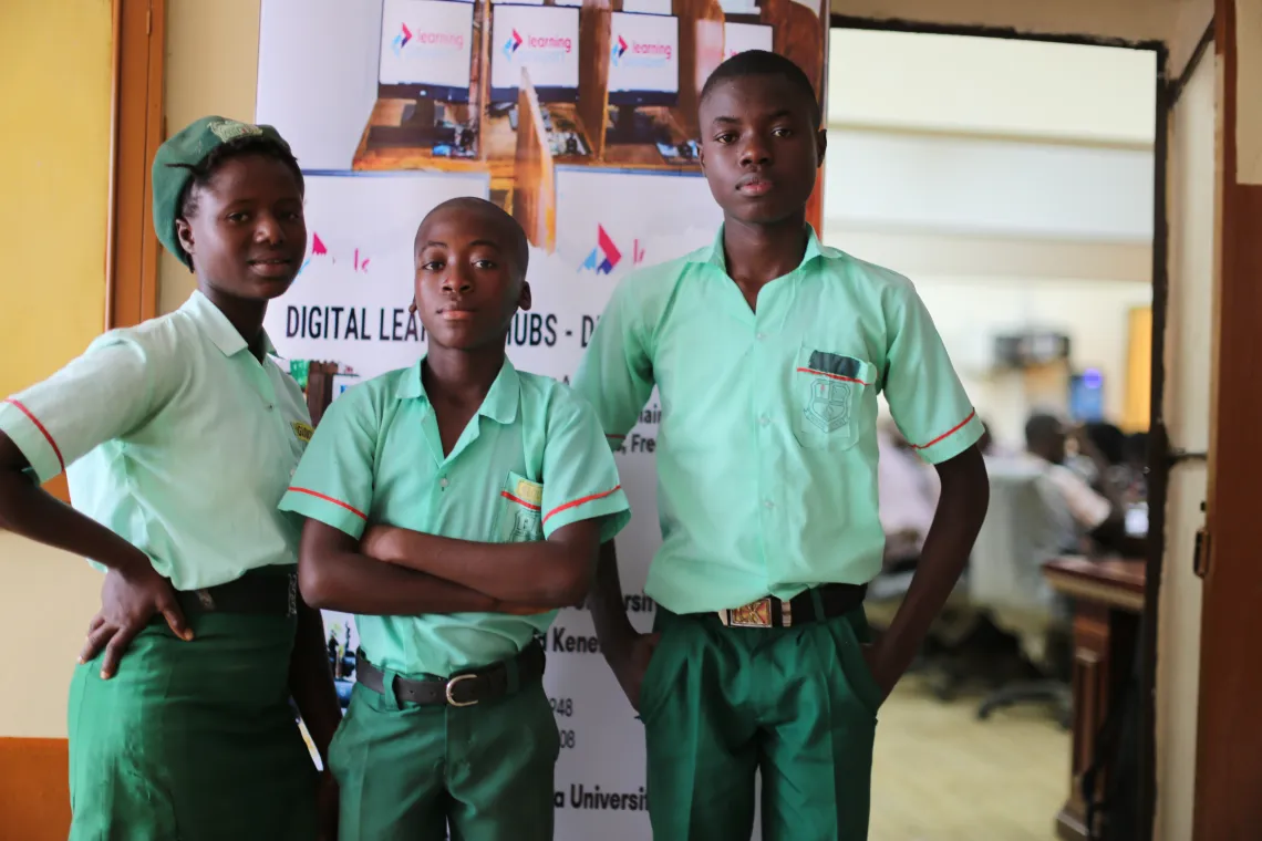 A group of school children stand by a door.