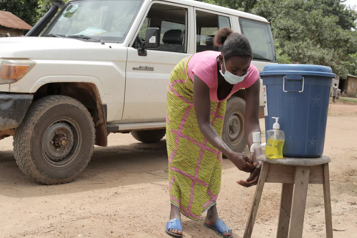 A woman washes her hand at a hand washing station in Kono, eastern Sierra Leone