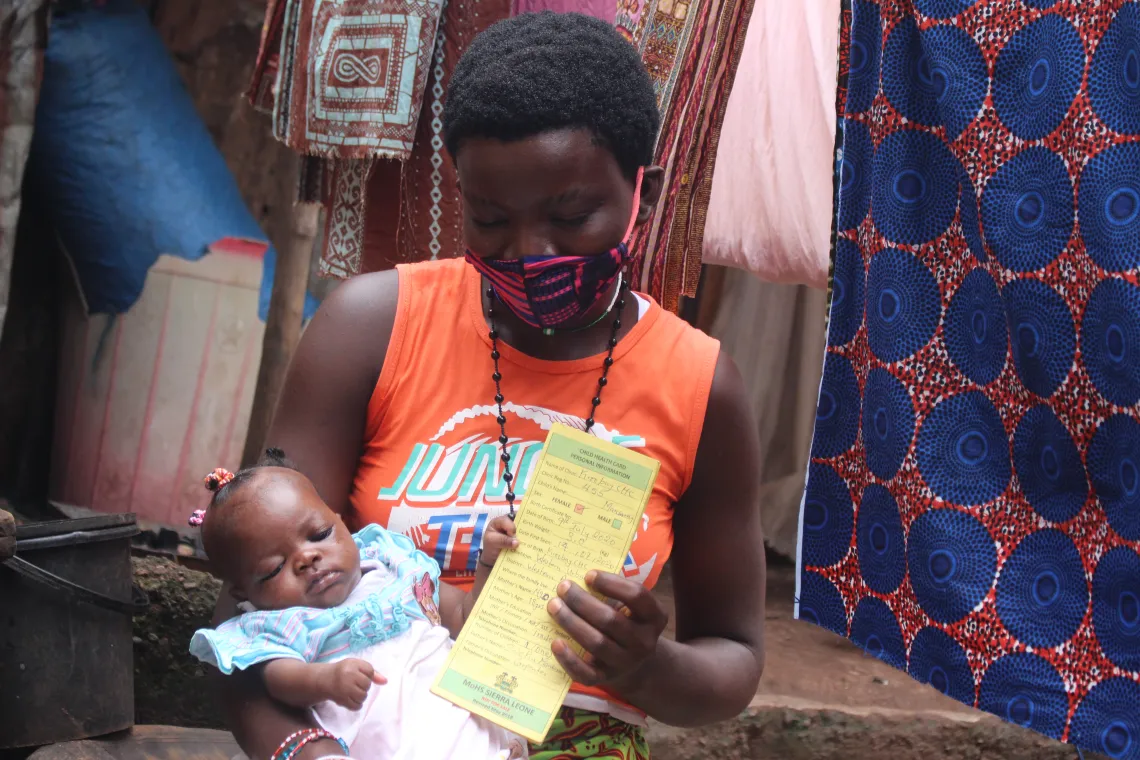 A mother carries her baby at their home in Freetown, western Sierra Leone