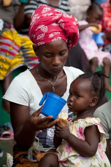 Flood affected children under five-years of age sheltering at Freetown's National Stadium receive nutritional support from UNICEF. BP-100 therapeutic food is made into porridge and distributed in individual cups to ensure hygiene.