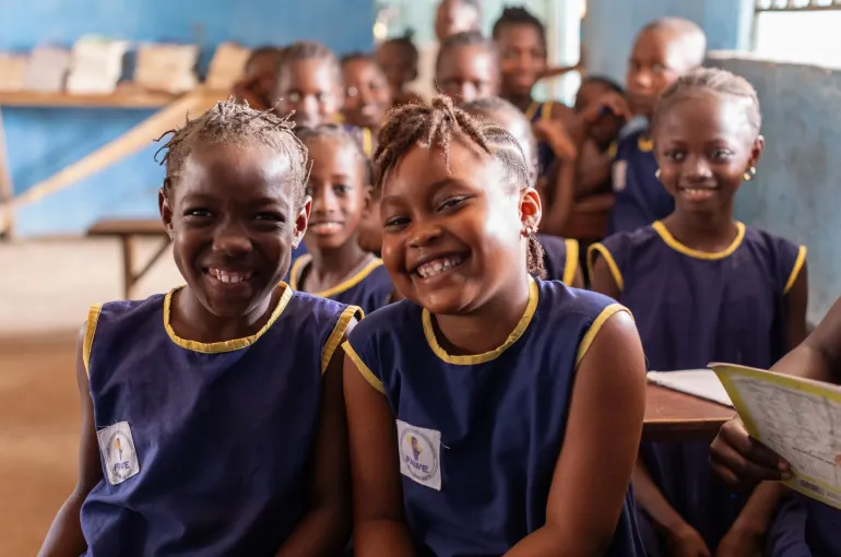A group of girls smiling at school.