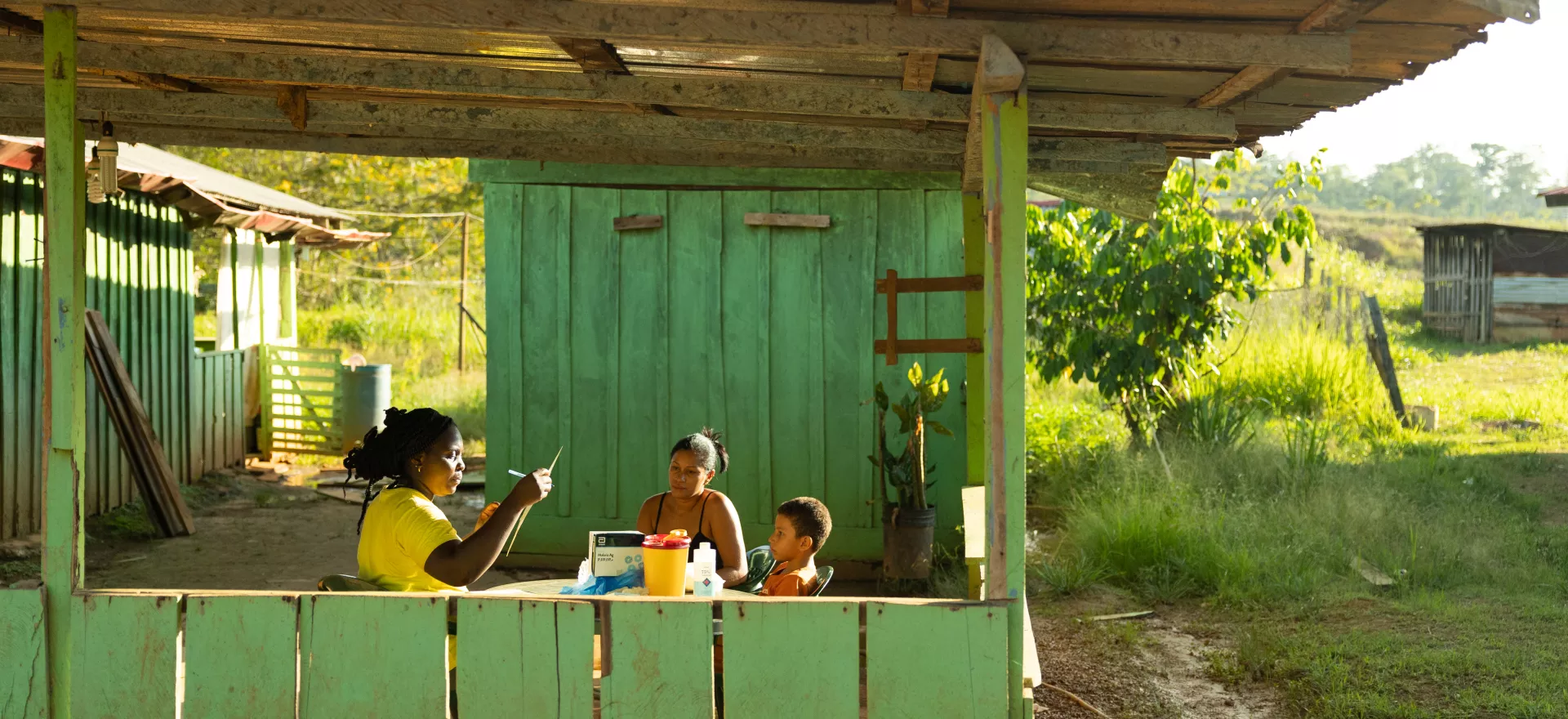 Hortance Nelson (Microscopist Superviser) doing a traditional Malaria test and Rapid Malaria test with Valeria Ferreira da Silva (Sex club owner) and Arthur Vinicius Ferreira da Silva (her son age 8) Vila Brazil Suriname.