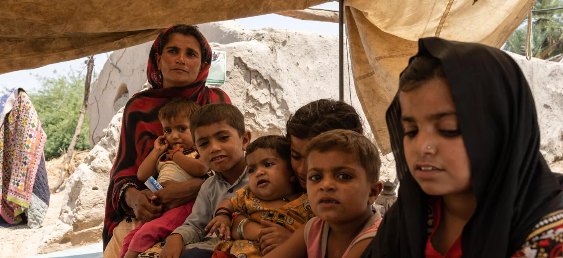 Pakistan. Benazi sits with her children in Balocho Zardari village, Sindh Province.