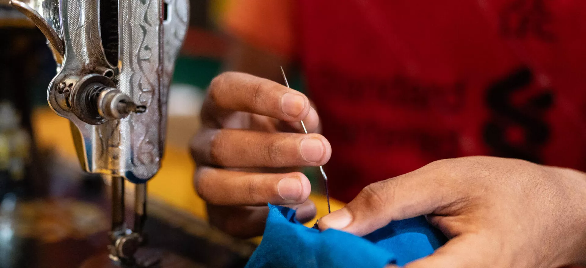 Bangladesh. A boy sews an item of clothing as part of a tailoring workshop at a Multi-Purpose Centre in a Rohingya refugee camp in Cox&rsquo;s Bazar, Bangladesh