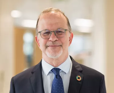 Man in suit and tie poses for photo in office.