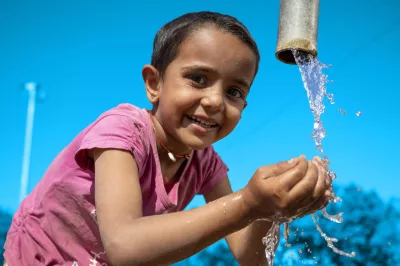 Jhanu (5 yrs) drinks water from the village hand pump near her anganwadi. Location : Village Amthala, Abu Road, Rajasthan.