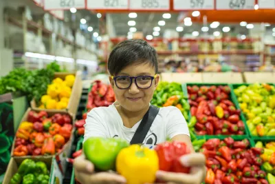 Kazakhstan. A boy holds some vegetables in a supermarket.