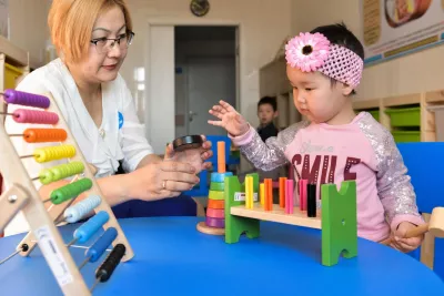 Una maestra juega con una ni&ntilde;a en un sal&oacute;n de clases