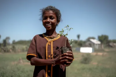 On March 7, 2025, at the Public Primary School of Terabovo in Sihanamaro commune, Androy region, Madagascar, 10-year-old Takaloaze, a 4th-grade student, holds a small tree sapling ready to be planted on the school grounds, as part of efforts to promote environmental education and greenery.