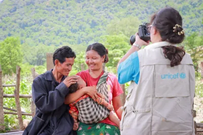 A UNICEF staff takes a photo of a family in Vungmaner Village, Lao PDR