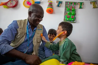 A UNICEF advisor plays with a child in Afghanistan.