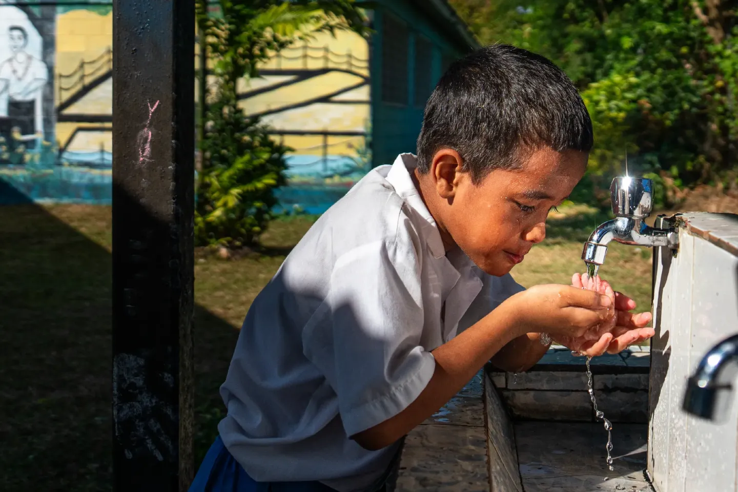 Boy drinking from a fountain