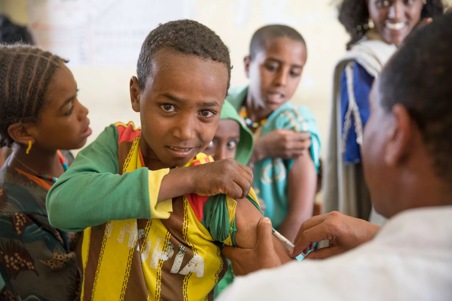 A boy holds up his shirt sleeve as he receives a measles vaccination, Ethiopia