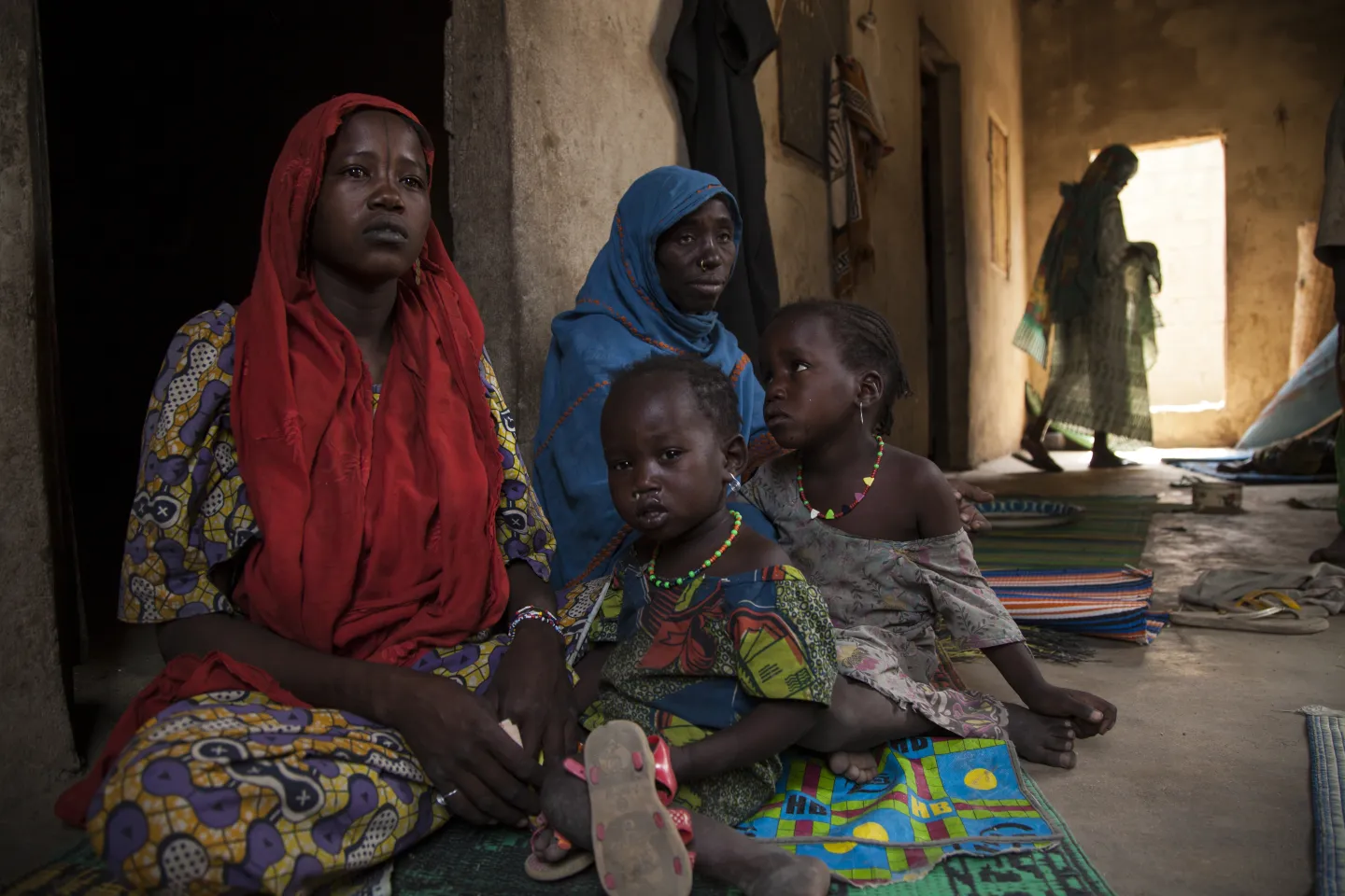 Residents of a so-called widows' house in Banki, Borno State, north-east Nigeria, sit with their children.