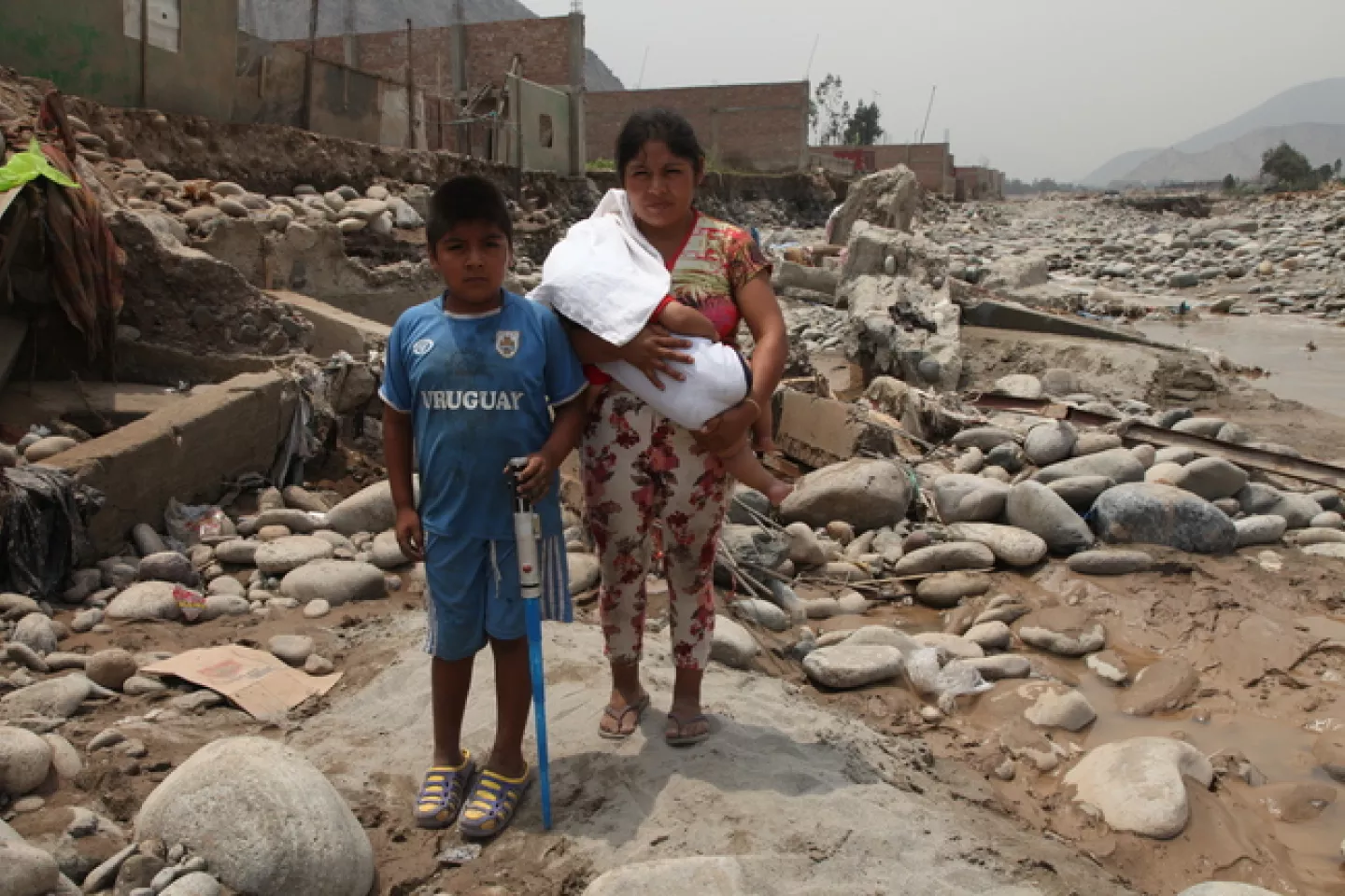 Hermilinda Cabrera and her sons, Aldony, 9, and Elias, 6 months, walk through a flooded road where their house used to be. 