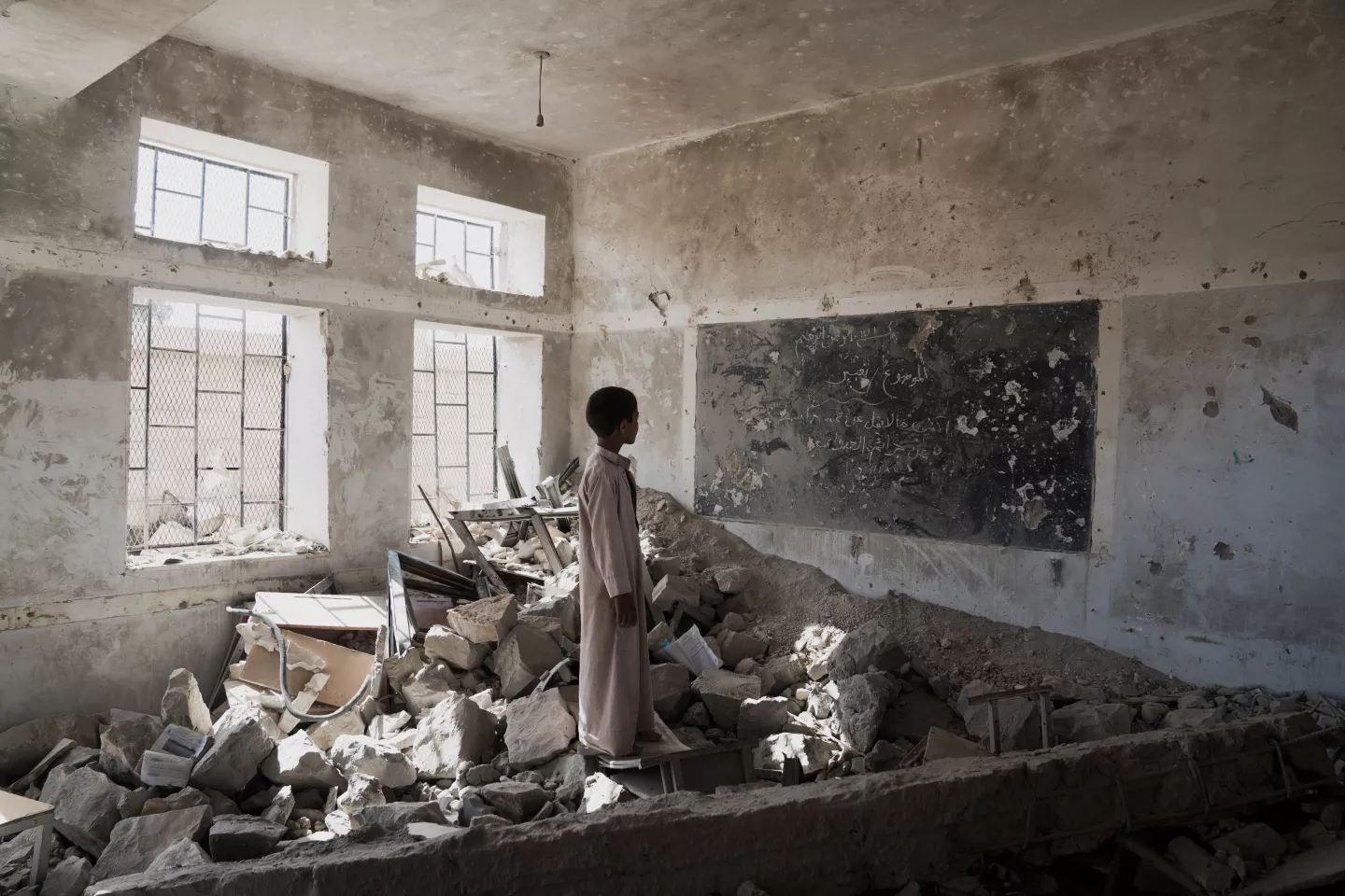 Un &eacute;l&egrave;ve se tient au milieu des ruines de l&rsquo;une de ses anciennes salles de classe, d&eacute;truite en juin 2015, &agrave; l&rsquo;&eacute;cole Al Okab de Sa&rsquo;dah, dans le gouvernorat de Sa&rsquo;dah, au Y&eacute;men, le lundi 24 avril 2017. Les &eacute;l&egrave;ves suivent d&eacute;sormais les cours dans des tentes de l&rsquo;UNICEF situ&eacute;es &agrave; proximit&eacute;.