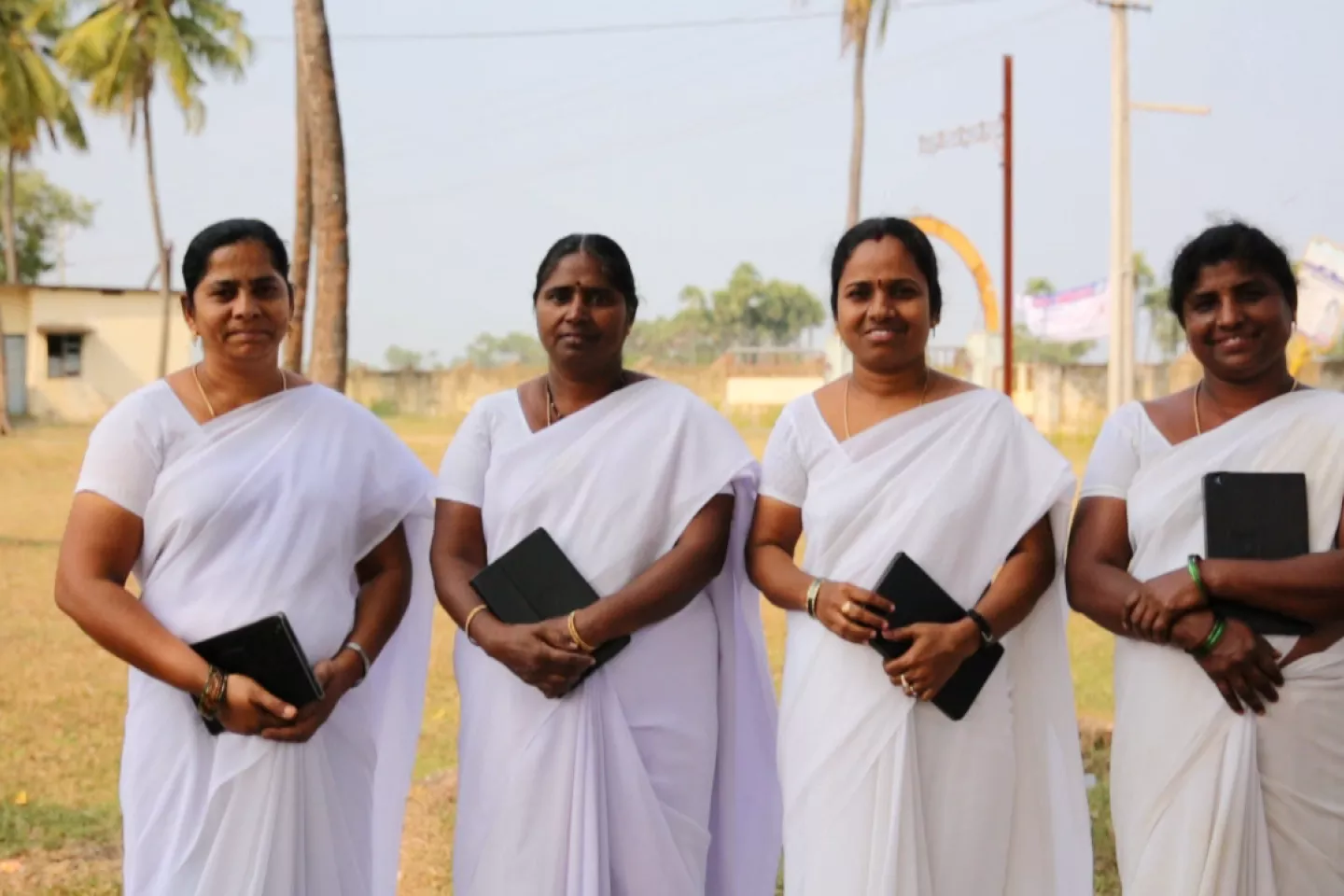 A group of Auxiliary Nurse Midwives (ANMs) in India holding tablets. 