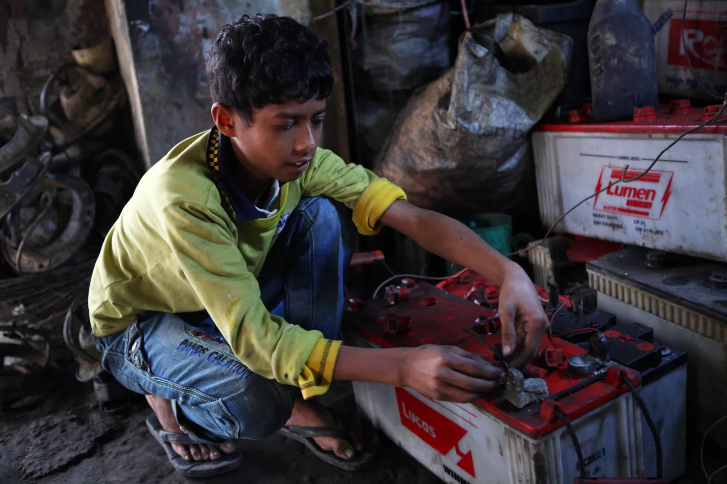Ten years old, Al Amin works at a garage where he repairs batteries near the Tangail New Bus Stand on 1 February 2014.