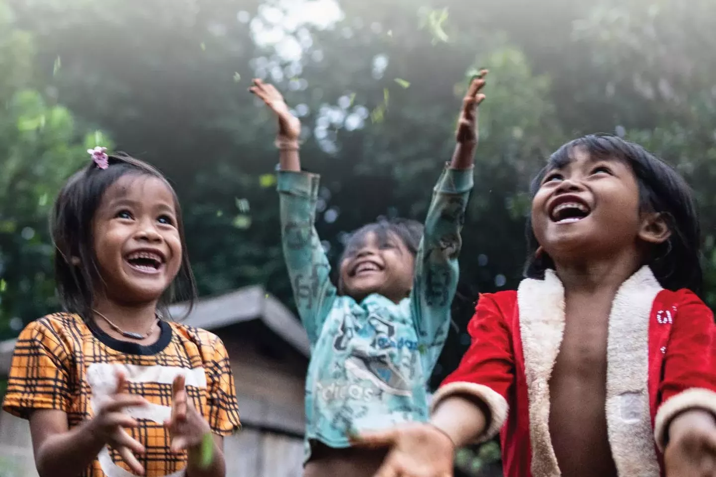 Three girls playing in the rain.
