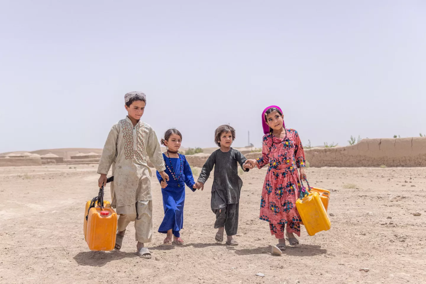 Children walk with their jerry cans to collect water from a UNICEF supported tap, located
