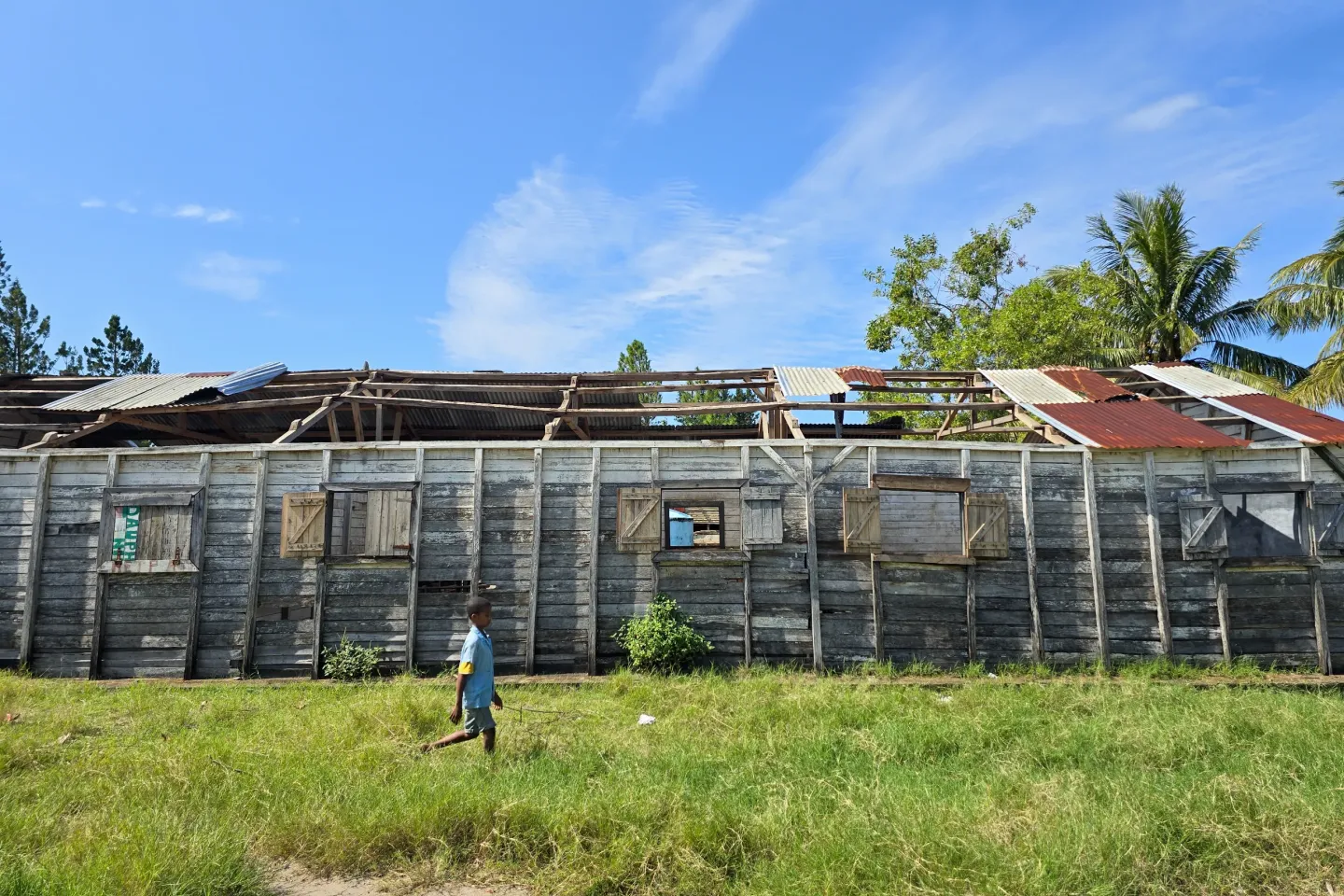 A student walking around a classroom destroyed by a storm.